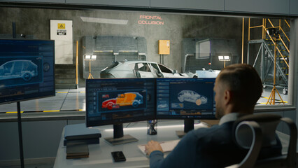An engineer in a crash test lab uses a car crash test system to simulate a traffic accident, to...