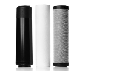 Filter cartridges for house water filtration system on white background. Foamed polypropylene, granular and briquettes carbon cartridges. Installation of reverse osmosis water purification system.