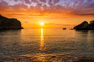 Fototapeta premium morning or evening landscape with nice beach , a sunrise or sunset in sea with amazing isle with rocks and beautiful clouds on background