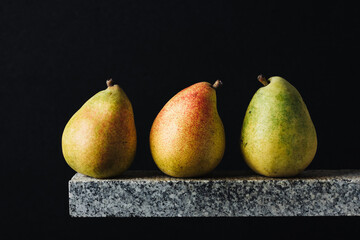 Ripe yellow pears on a dark background.