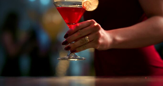 Cocktail drink, bar and woman in nightclub with wine glass for martini, alcohol and red champagne of party, happy hour or restaurant. Closeup lady, hands and liquor from bartender at social pub event