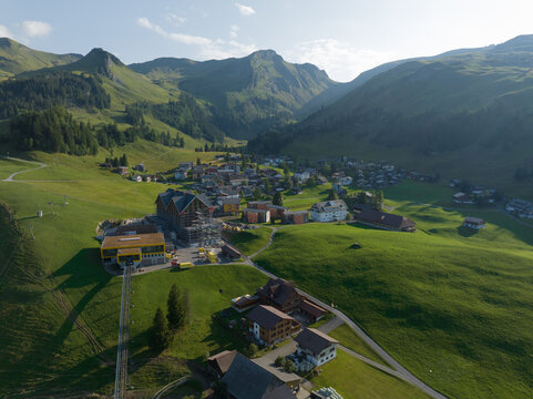 Schwyz Switzerland mountain village. Green summer hiking village. Aerial drone alpine destination overhead nature landscape. Alp grass and trees.
