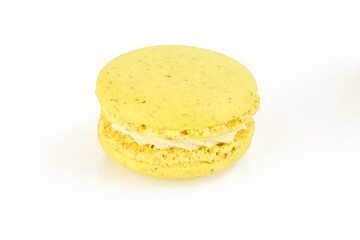 Single yellow macaroon with white filling cream isolated on white background. French macaron delicacy