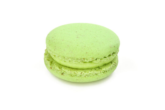 Single green macaroon with green filling cream isolated on white background. French macaron delicacy