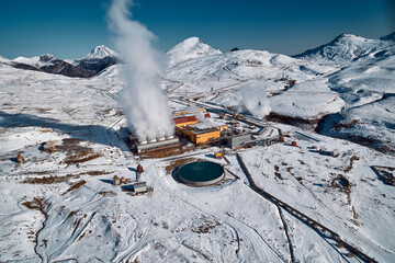 Aerial view to geothermal power plant in mountain. Clean green renewable energy in Kamchatka. - 550932440