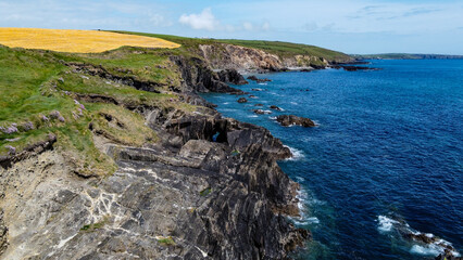 Fototapeta na wymiar Farm fields on the rocky shore of the Celtic Sea, south of Ireland, County Cork. Beautiful coastal area. Turquoise waters of the Atlantic. Picturesque stone hills. Aerial photo. View from above.