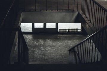 Grayscale of descending handrail stairs at home with grunge floor