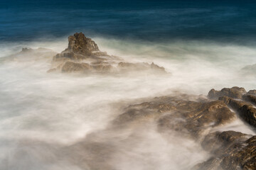 Rocks in the moving sea long exposure