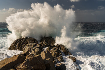 The waves of the ocean thunder against the rocky shore