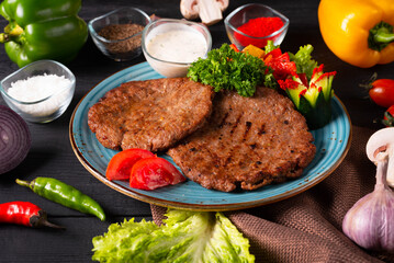 meat cutlets with sauce, fresh vegetables and herbs