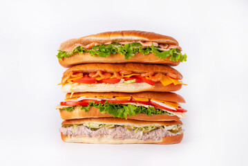 four sandwiches standing on top of each other on a white background