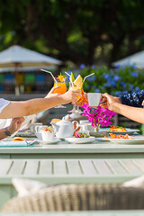 Breakfast and hands clinking drinks,Group of people having brunch together at table, top view