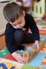 expressive young boy playing with toys in the baby room at home