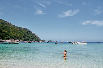 Obraz premium Vacation on the seashore. Young woman bathing on the beautiful tropical beach.