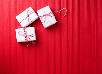 Three wrapped boxes with presents on  red textured  paper background.  Place for text. Top view.