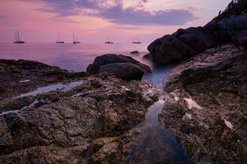 Sea landscape with sunset sky and boats on the horizon