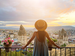 Young woman in dress on the roof with amazing view of Cappadocia in Turkey