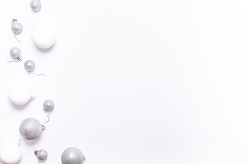 White and silver Christmas balls on white background with copy space for your design. Minimalism style Christmas and New Year border.