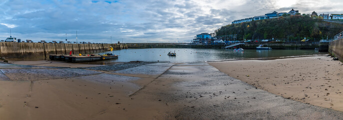 A panorama view down the slipway into the harbour at high tide in Saundersfoot, Wales in winter