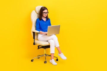 Full body length photo of young manager work office sit armchair use laptop online chatting with her boss remote isolated on yellow color background