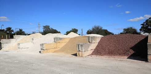 Large quantities of different landscaping rocks, stones, sand and fill for sale at a local supply shop. 