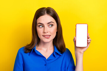 Naklejka premium Portrait photo of young success entrepreneur business owner lady wear blue shirt look empty space phone menu app isolated on yellow color background