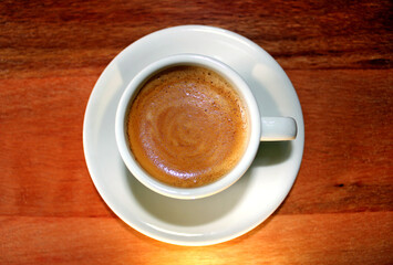 White cup of coffee on the wooden table