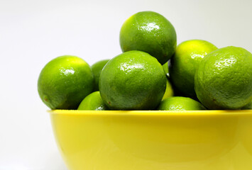 Yellow bowl with fresh green limes
