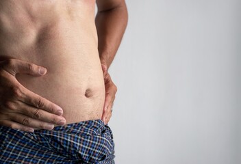 Abdomen of Asian man. Concept of central obesity, belly fat, abdominal bloating or fullness.