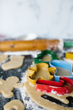 Colorful Christmas shaped cookies cutters on fresh rolled dough