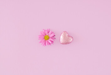 Creative Valentines day concept. Decorative pink heart and flower on pastel pink background. Theme of love. Copy space. Flat lay, Top view.