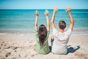 Young couple on the beach summer vacation. Happy man and woman look at the sea 
