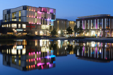 colourful modern buildings, with reflections, at night