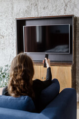 Woman press button on remote control, turn on tv
