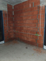 Brick walls in a newly built house. On the walls attached electrical wires