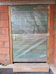 Timber doors in a newly constructed building. Wooden door locked with a padlock.