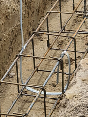 Steel reinforcement of foundations for a newly built house. The steel prets lie in the ground