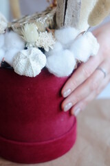 Hands compose the decoration. The are objects on the table. Scissors, vases, and flowers	
