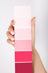 Hand holding Color samples palette design catalog. New 2023 trending PANTONE Viva magenta colour