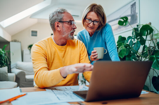 Senior Middle Aged Happy Couple Using Laptop Together At Home