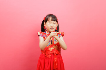 Chinese young girl  with traditional  dress with  gesture of happy new year congratulation isolated on pink background.