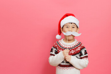Merry Christmas! Young girl celebrating Christmas against pink background