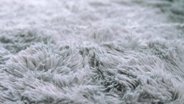 girl touching the rug close up, stroking area rug, runs his hand over the rug, area rug on the floor, fluffy carpet close-up