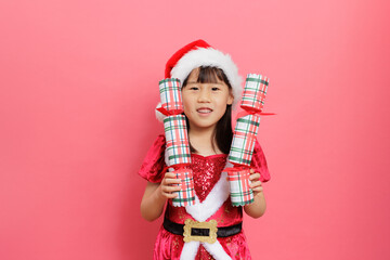 Merry Christmas! Young girl celebrating Christmas against pink background