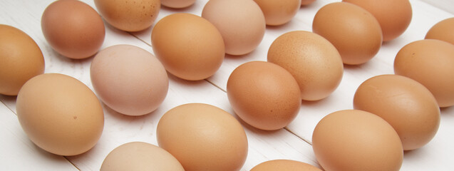 fresh chicken eggs laid out in rows on a white wooden table.selective focus. 