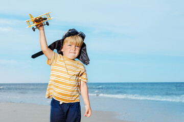 Portrait of a cute little boy standing with toy model plane