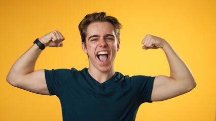 Portrait of young hipster man 20s with show muscles, have fun energy isolated on yellow background...