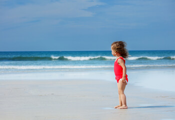 Fototapeta na wymiar Beautiful girl stand on ocean sand beach in swimsuit, profile