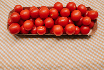Fresh ripe red cherry tomatoes in a bowl on the table. Healthy food, organic vegetables. Natural vitamins, food raw materials. Handpicked bio tomato
