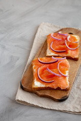 Homemade Smoked Salmon Toast on a rustic wooden board, side view. Copy space.